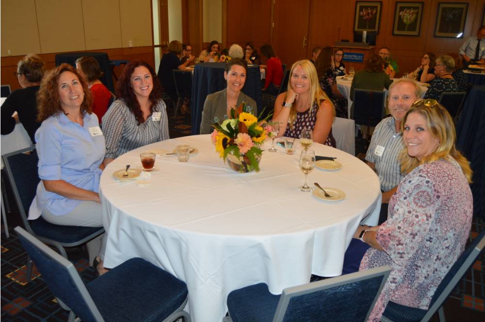 Six alumni gathered at a table at the KCON alumni reception